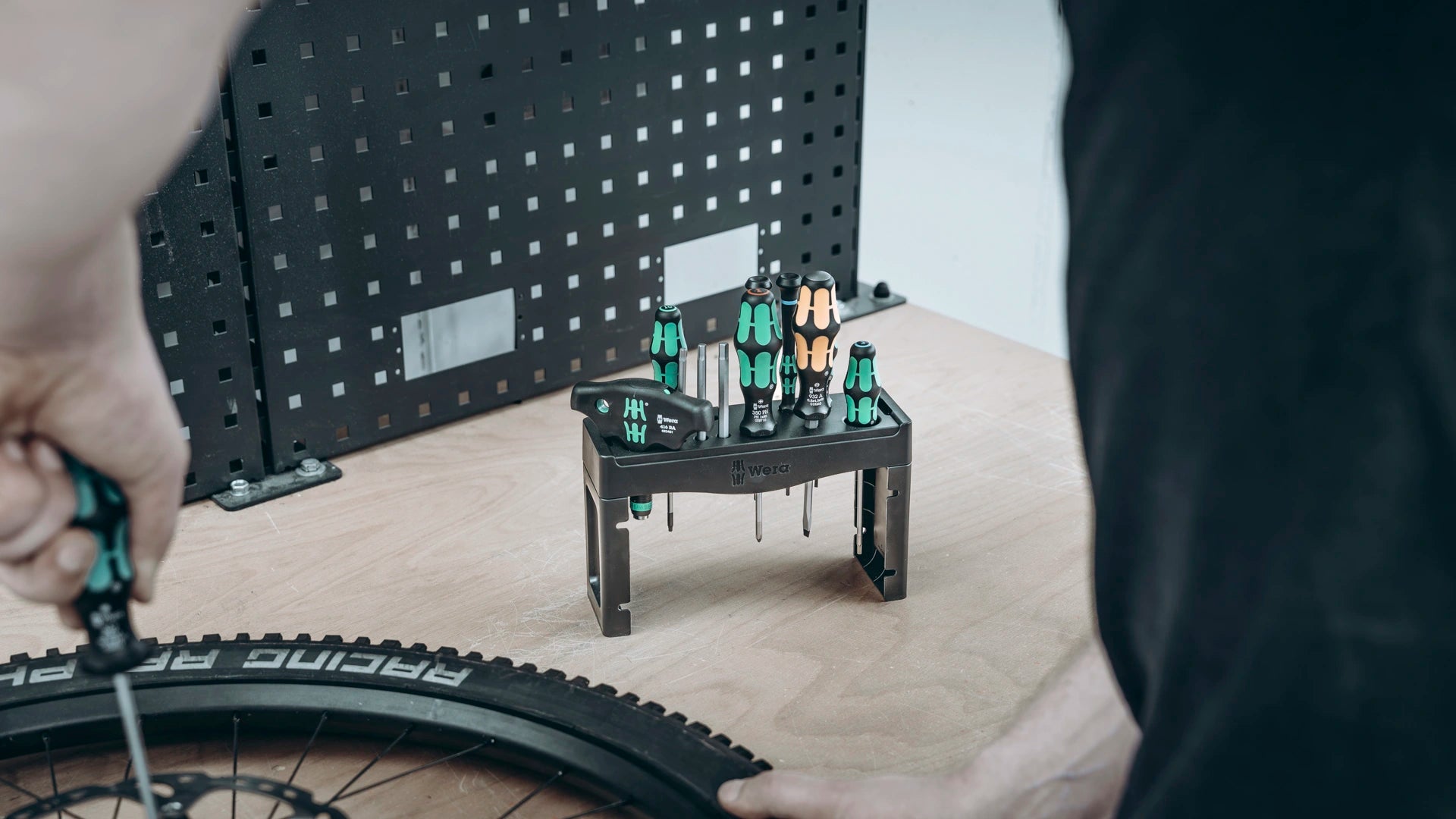Wera Tool Rebel Shop Fahrrad Wartung Set Person arbeitet mit Schraubendreher an einem Fahrradreifen